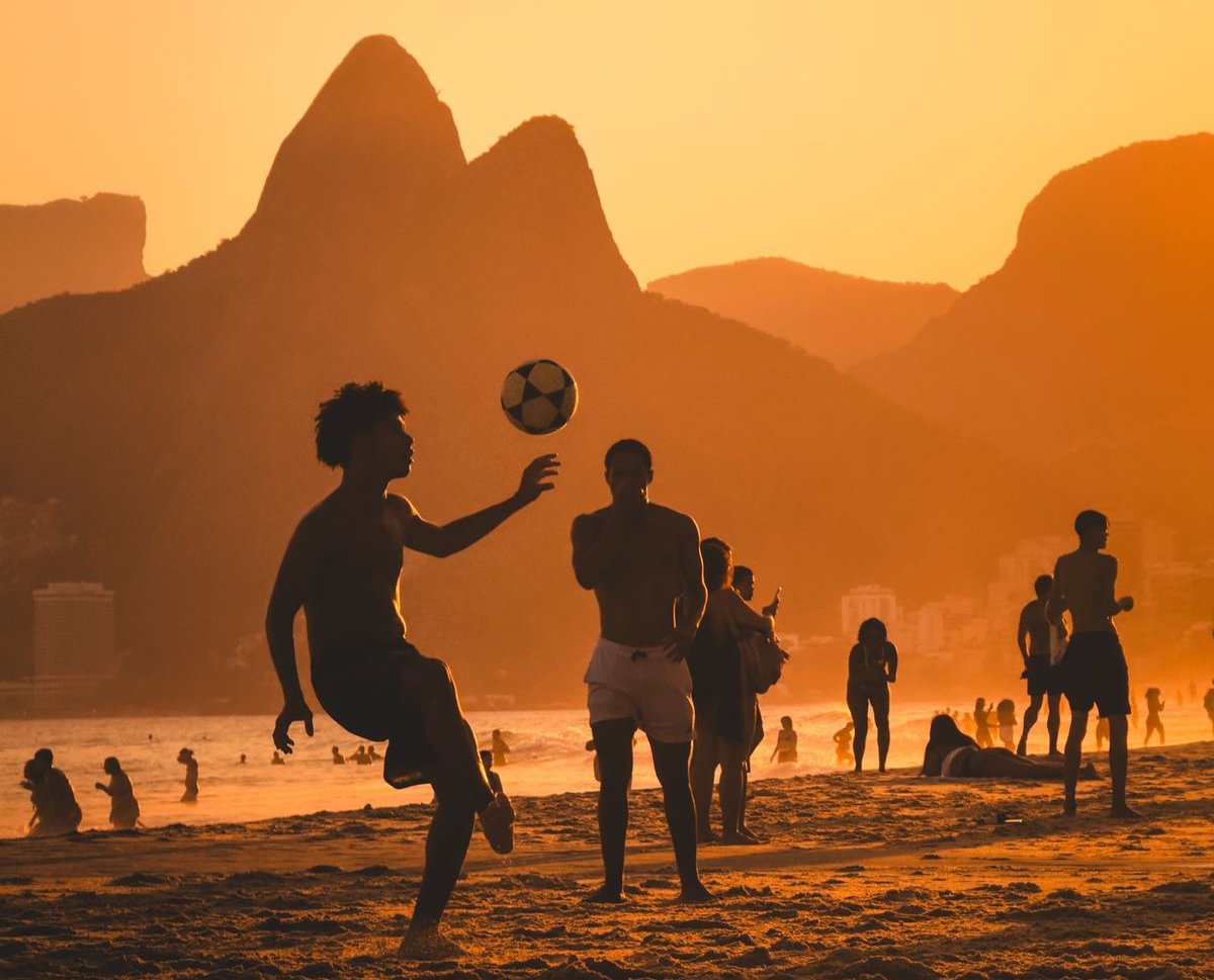 Futebol na praia ao pôr do sol